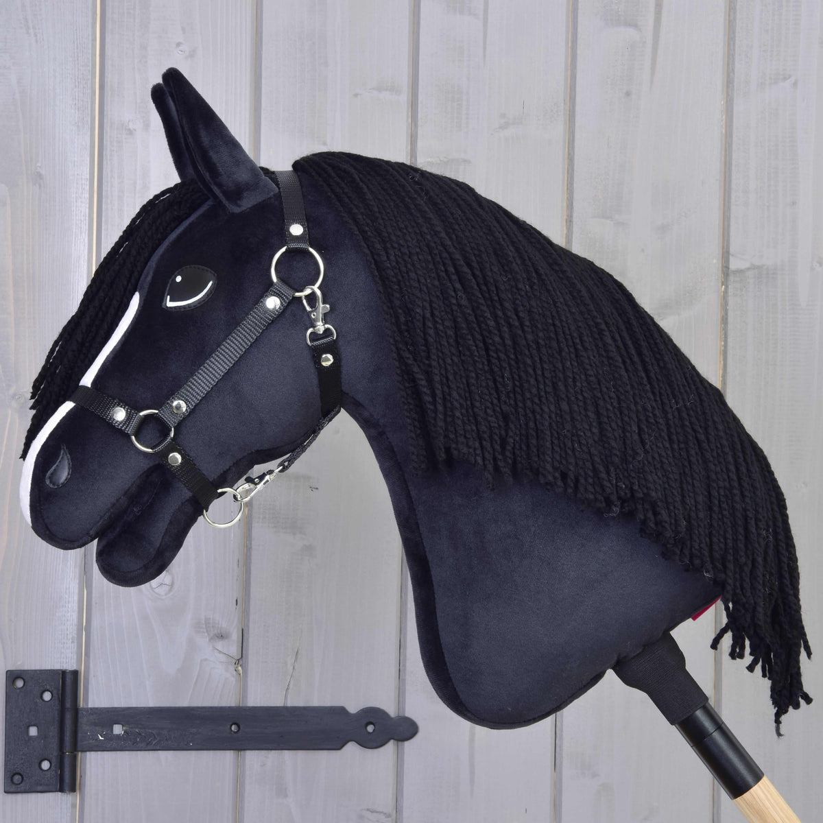 Hobby Horse Freya ló bal profilból, a nyakát takaró hosszú fekete fonalsörénnyel és fekete kötőfékkel