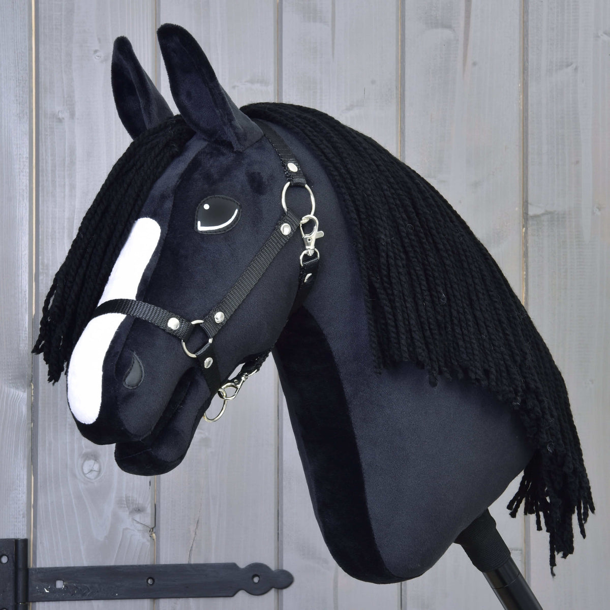 LarDen Hobby Horse Freya, fekete kötőfékkel: fekete plüss lófej fehér hókával és hosszú fekete fonalsörénnyel