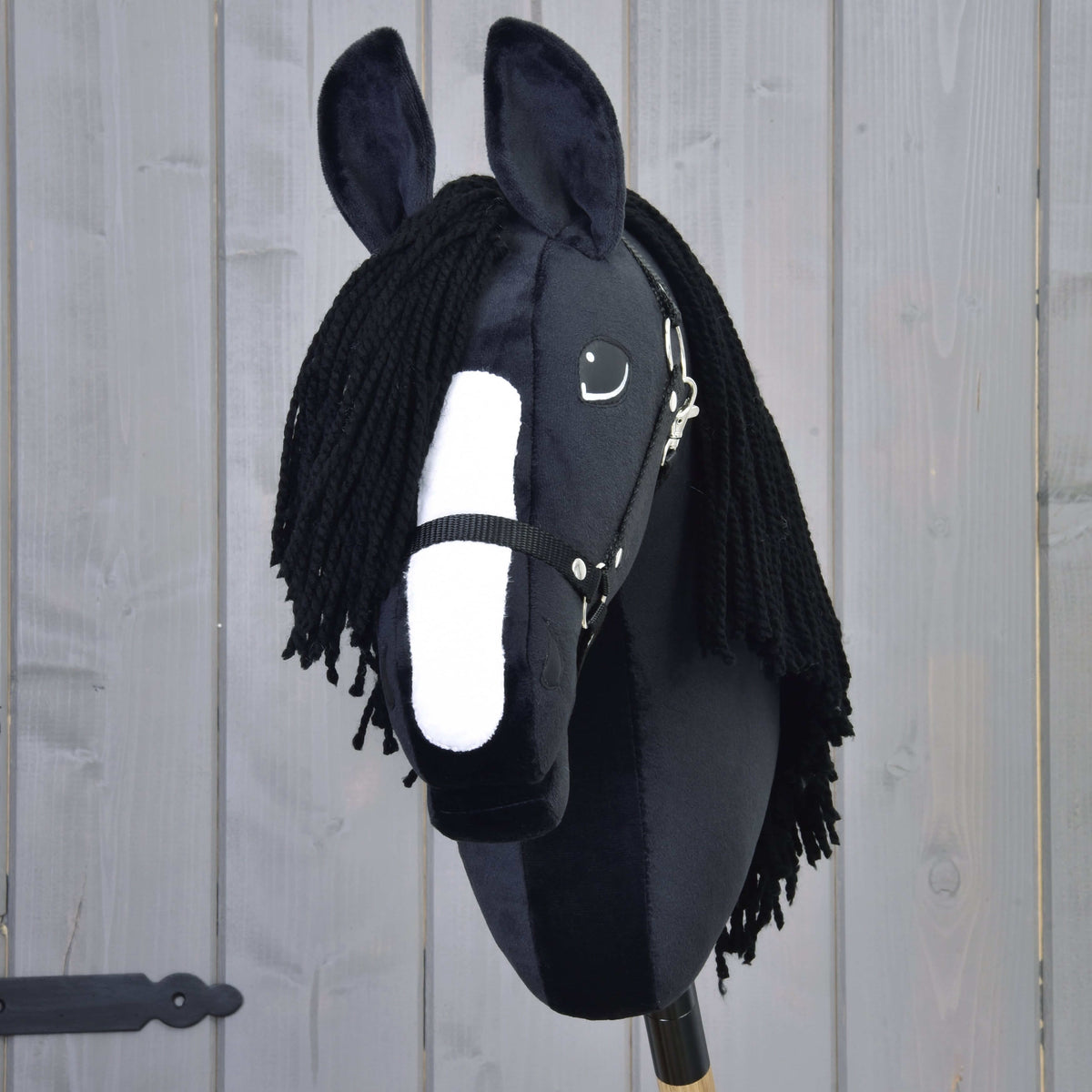 Hobby Horse Freya ló elölnézetből, széles fehér hókával, fekete fonalüstökkel és fekete kötőfékkel