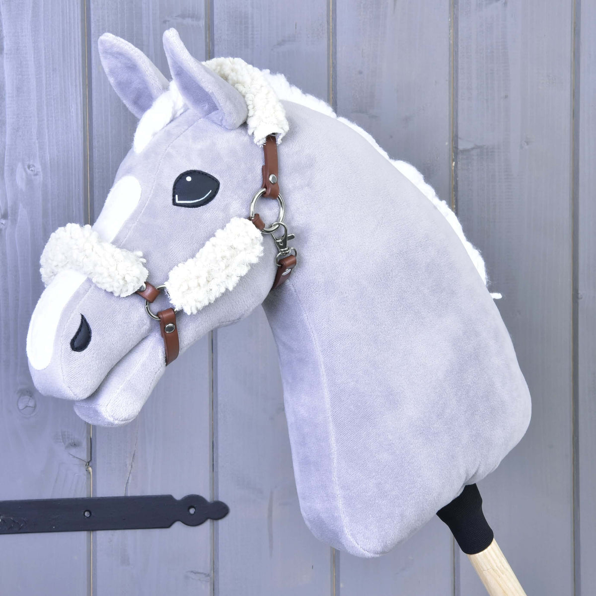 Light grey Hobby Horse with a white mane wearing the brown leatherette halter with cream fur on the crown and noseband