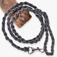 LarDen Hobby Horse Knitted Lead Rope Graphite, a braided grey paracord lead with silver snap hook, coiled over a wooden branch