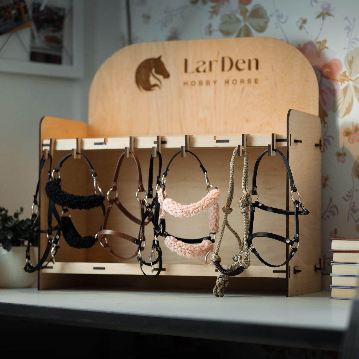 Fa LarDen Hobby Horse bemutatóállvány kötőfékekkel: fekete és rózsaszín szőrmés, barna és fekete műbőr, valamint egy bézs csomózott kötőfék