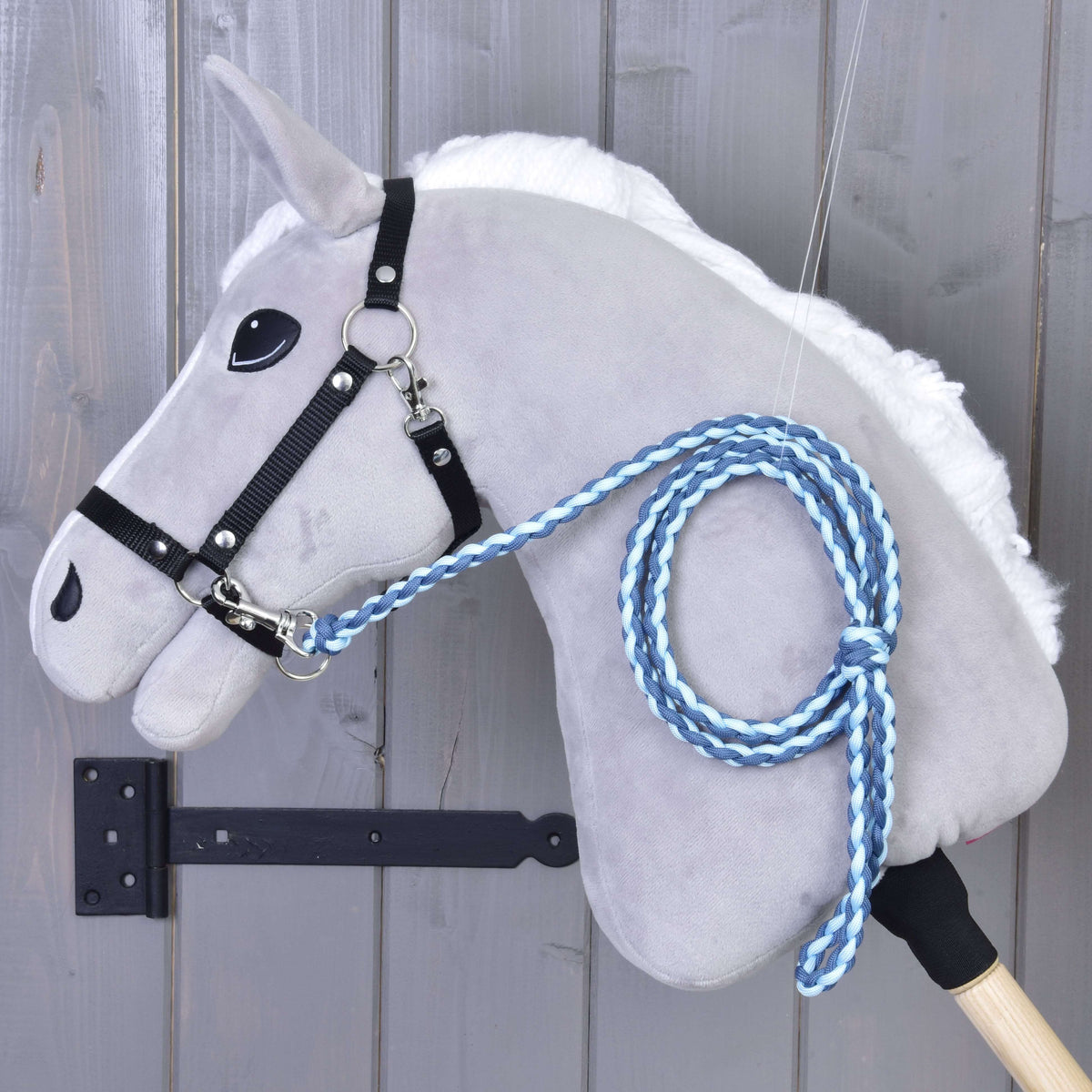 Fekete kötőfékes szürke Hobby Horse ló, a nyakára tekerve a sötétkék és világoskék fonott vezetőszár