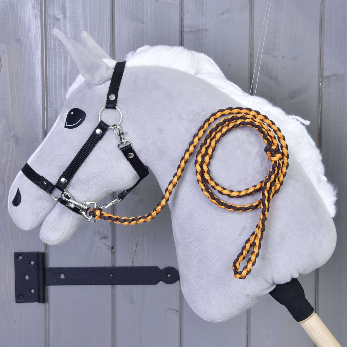 Narancssárga-fekete fonott vezetőszár egy fehér sörényű szürke Hobby Horse ló fekete kötőfékére csatolva