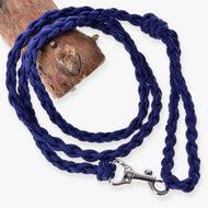 LarDen Hobby Horse Knitted Lead Rope Royal Blue, a braided paracord lead with silver snap hook coiled beside a log