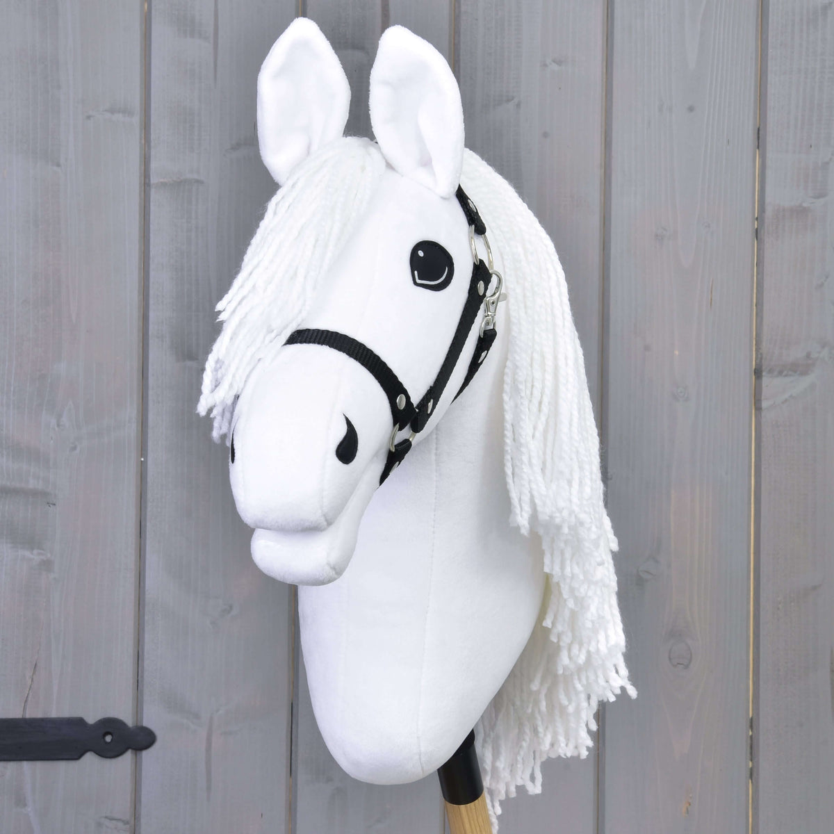 Fehér Hobby Horse ló elölről, fehér fonalüstökkel, fekete szemekkel és fekete kötőfékkel