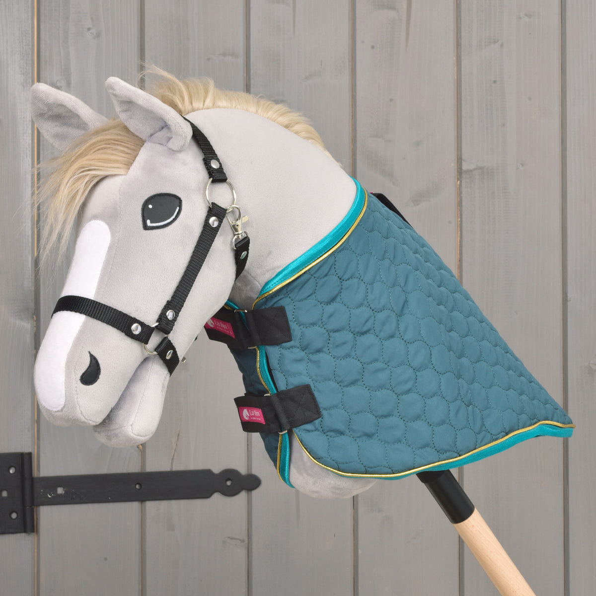 The Lagoon blanket worn without its neck cover on a grey Hobby Horse, with turquoise binding and gold piping at the neck
