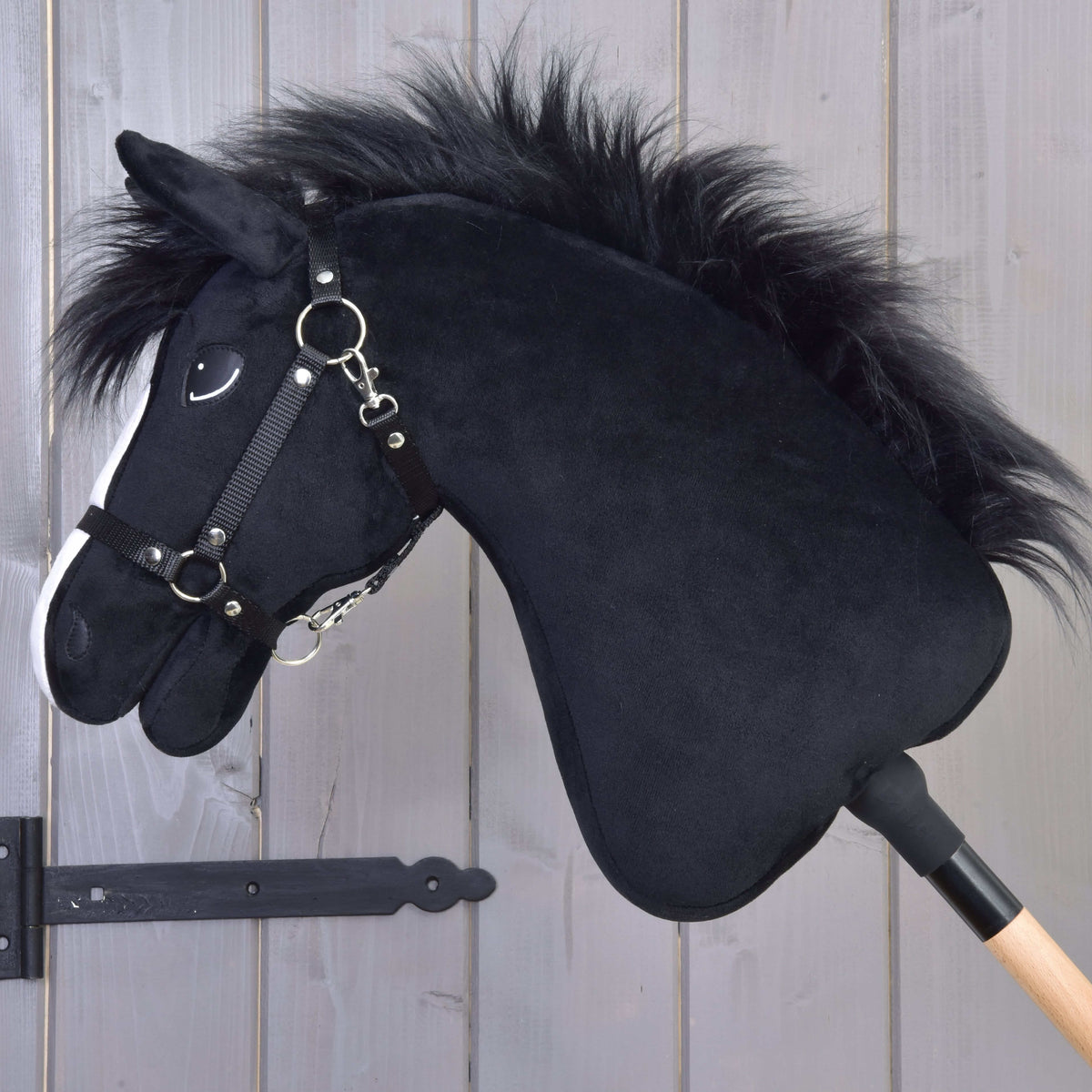 Hobby Horse Loki in left profile with a long shaggy black faux fur mane and a black halter