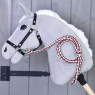Maroon and cream braided lead rope clipped to the black halter of a grey Hobby Horse by a grey wooden wall