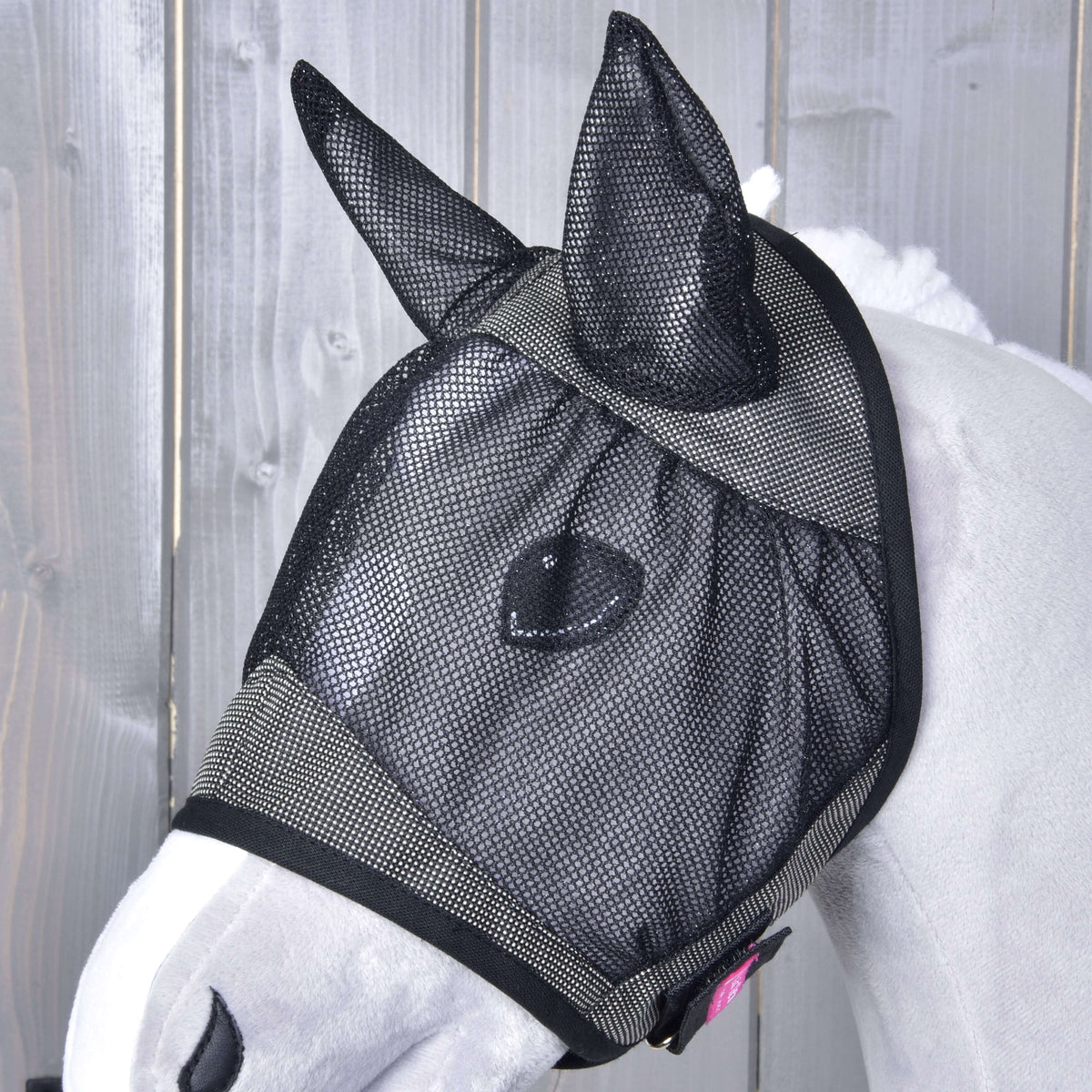 Hobby Horse Fly Mask De Luxe Grey up close on a light grey head: black mesh ears, eye net and a small pink tag