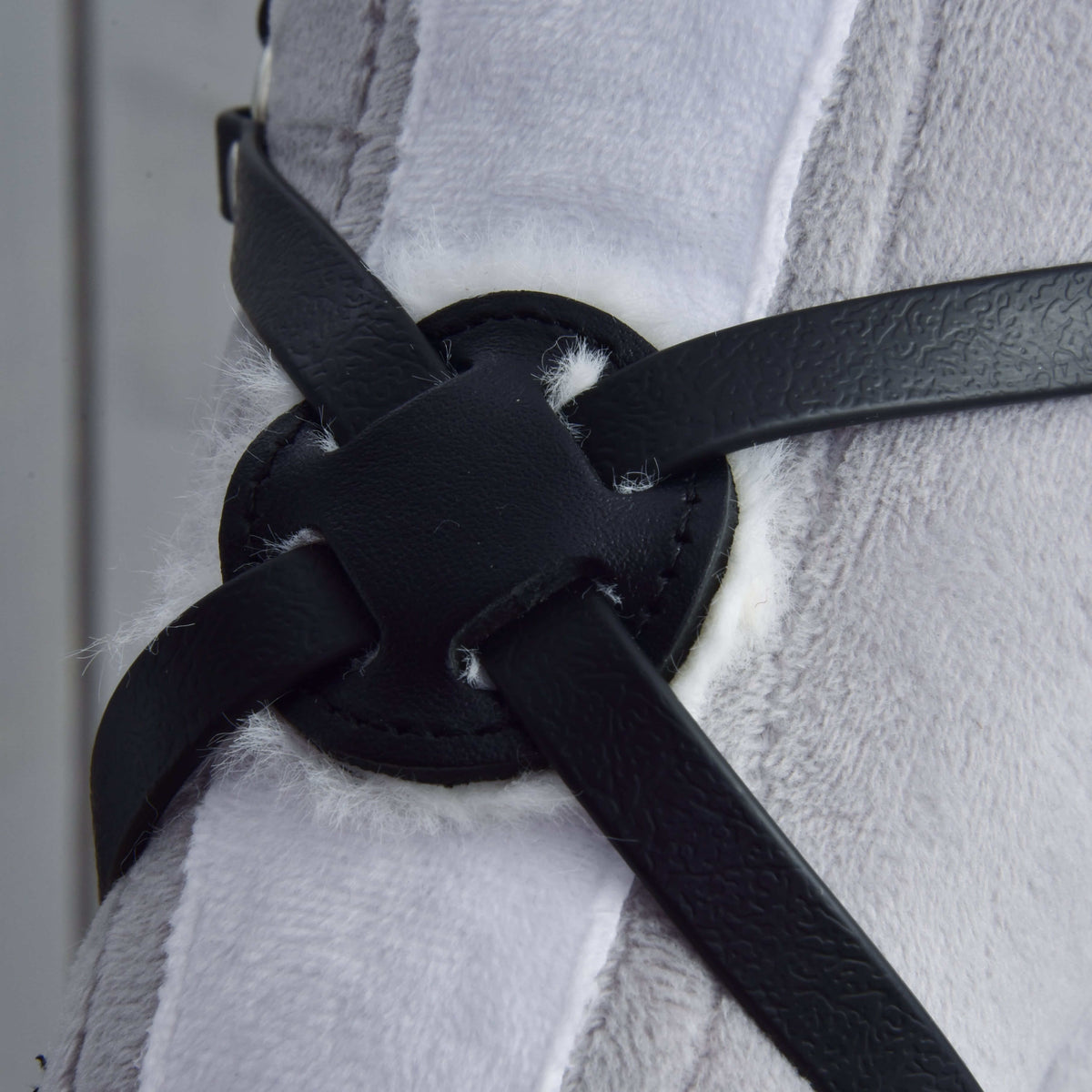 Front close-up of the round padded centre of the Mexico noseband, stitched black leatherette with white fleece edging