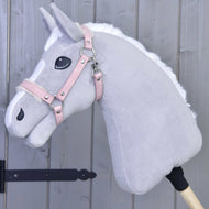 Fehér sörényű világosszürke Hobby Horse ló a púderrózsaszín műbőr kötőfékben, krémszínű szőrmeszegéllyel