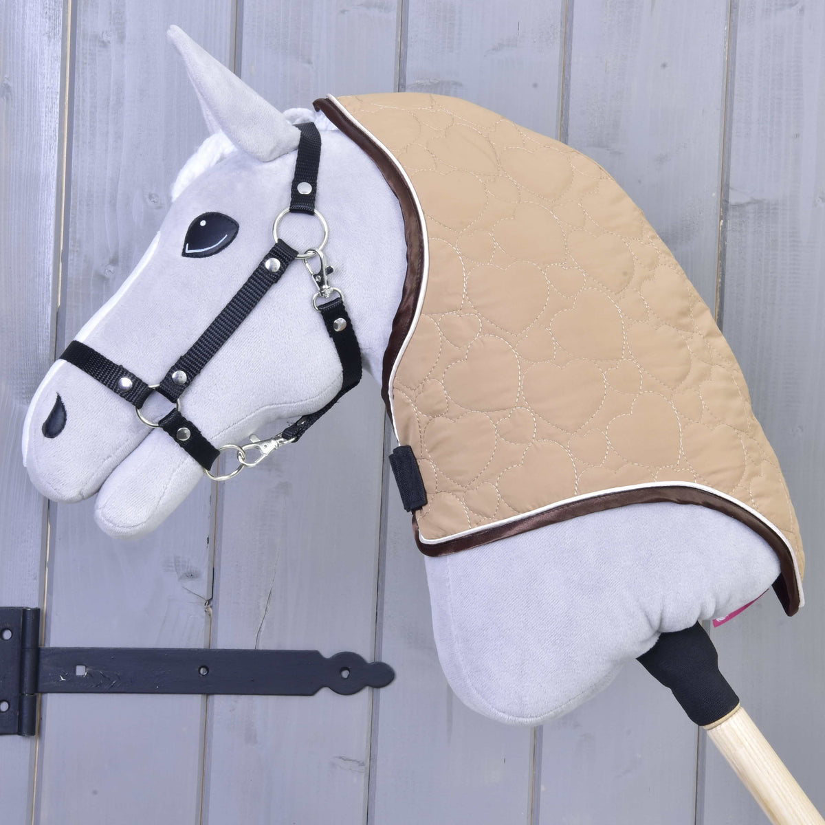 Fekete kötőfékes szürke Hobby Horse ló a bézs, szívmintásan steppelt, barna szegélyű nyakrészben
