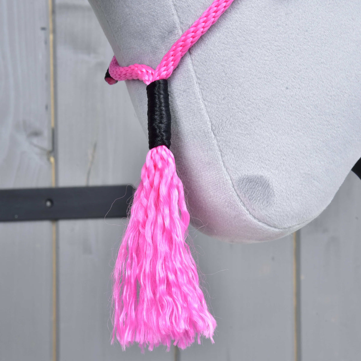 Pink tassel of Cordeo Pink Festive with a black wrapped top, hanging below the jaw of a grey Hobby Horse