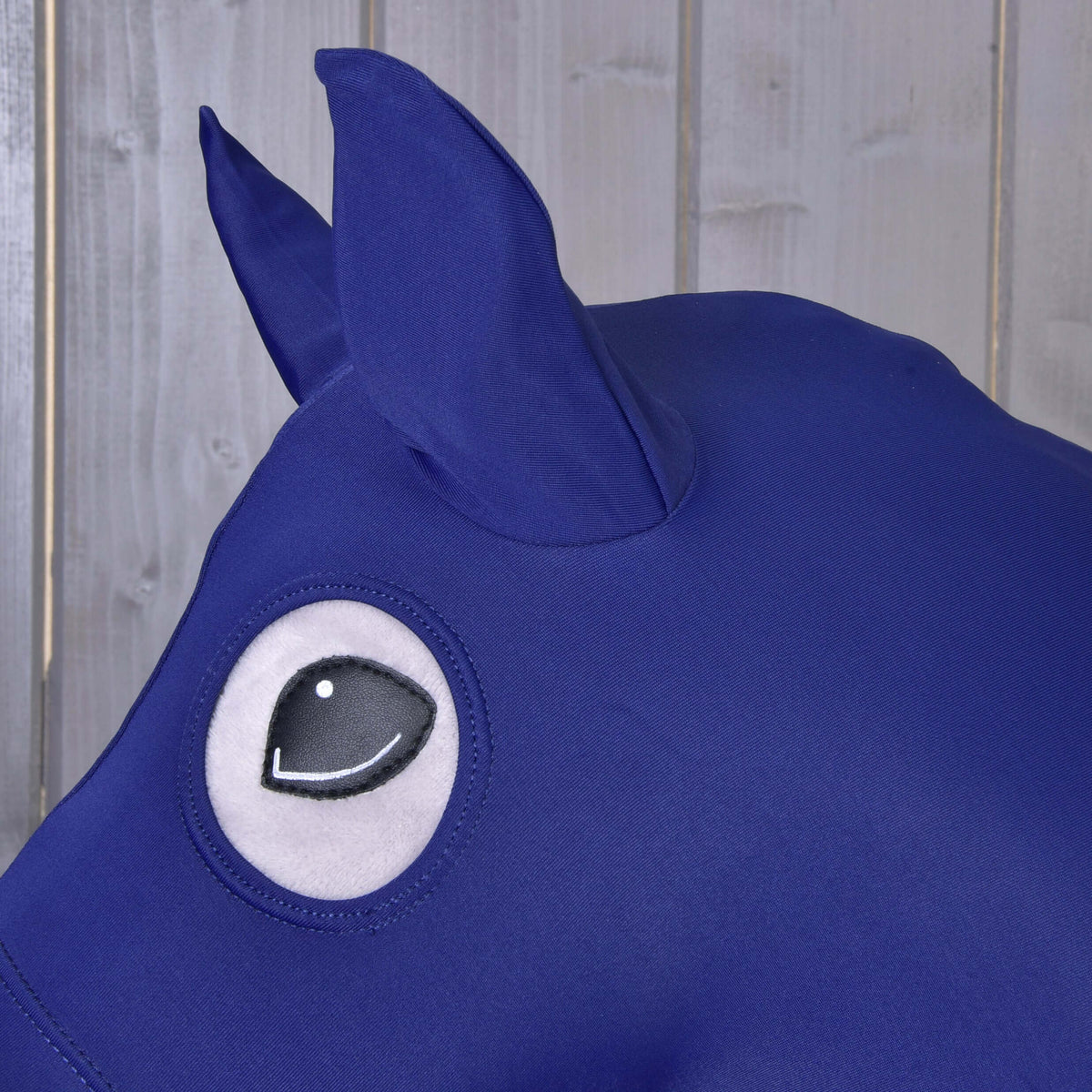 A Hobby Horse védőruha sötétkék Lycra fülei és kerek szemnyílása közelről, átlátszik a fekete szem