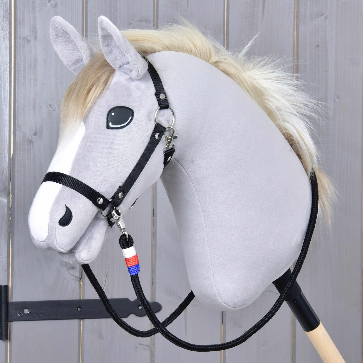 Emblem CZ kantárszár egy krémszínű sörényű, fekete kötőfékes szürke Hobby Horse lovon, az álla alatt fehér-piros-kék tekeréssel