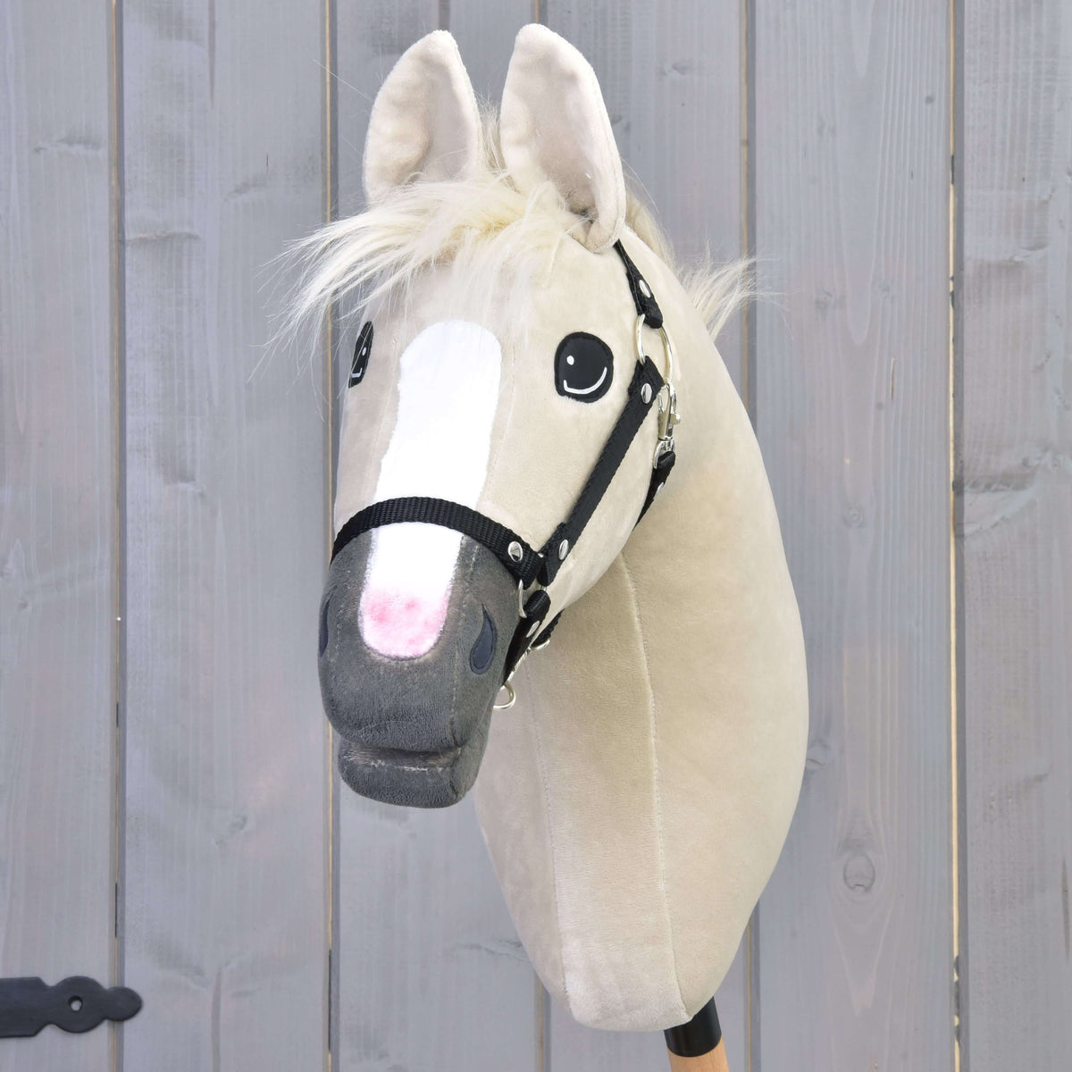 Hobby Horse Pixie ló elölnézetből, rózsaszínbe olvadó fehér hókával, szürke orral és fekete kötőfékkel
