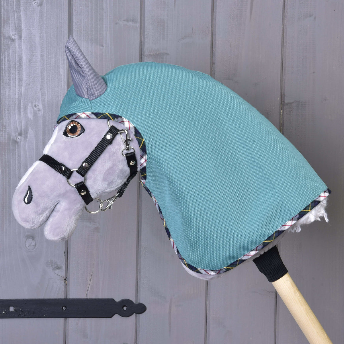 Side view of the Summer raincoat Emerald on a grey Hobby Horse with a black halter, covering the neck, with plaid binding
