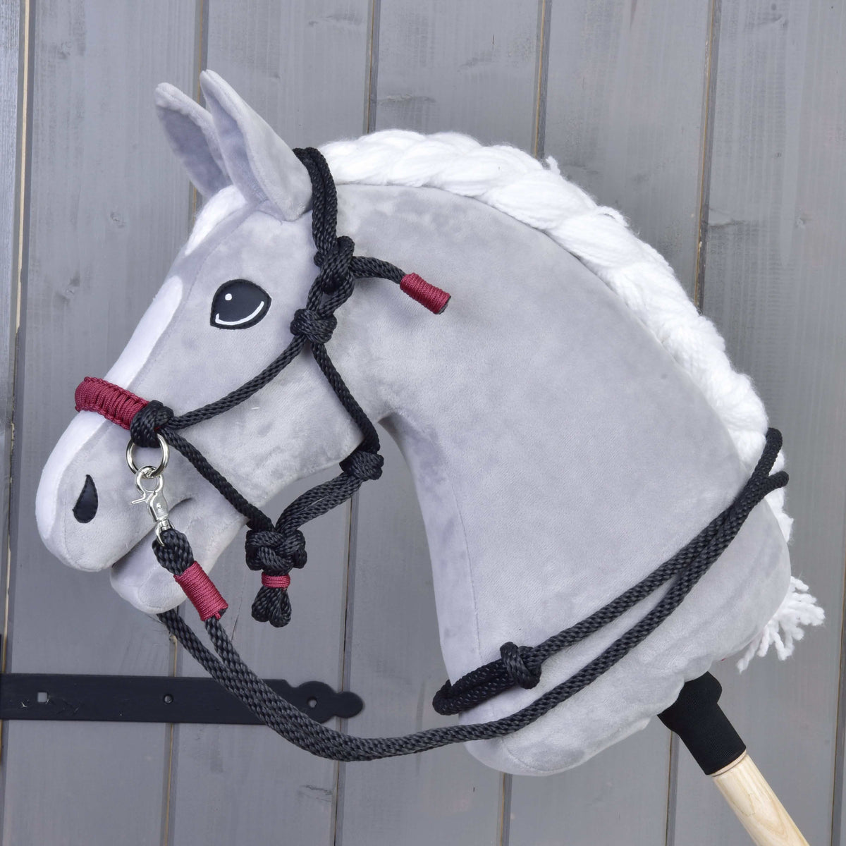 Grey Hobby Horse with a white braided mane wearing the Rope set Maroon, a black rope halter and reins with maroon wraps
