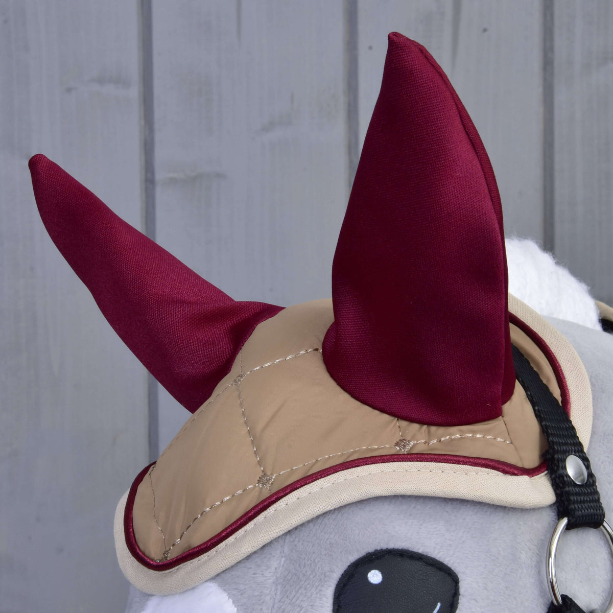 Close-up of the beige quilted ear bonnet with burgundy ears, burgundy piping and cream edging on a Hobby Horse