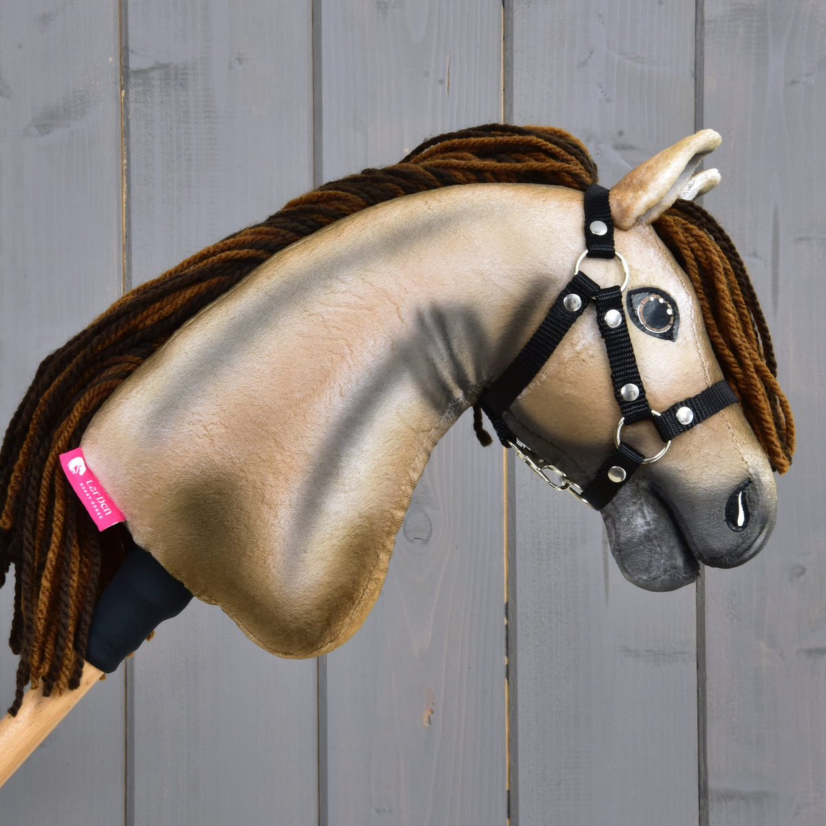 Right profile of Hobby Horse Ruby with a pink LarDen label on the neck, black halter and brown yarn mane
