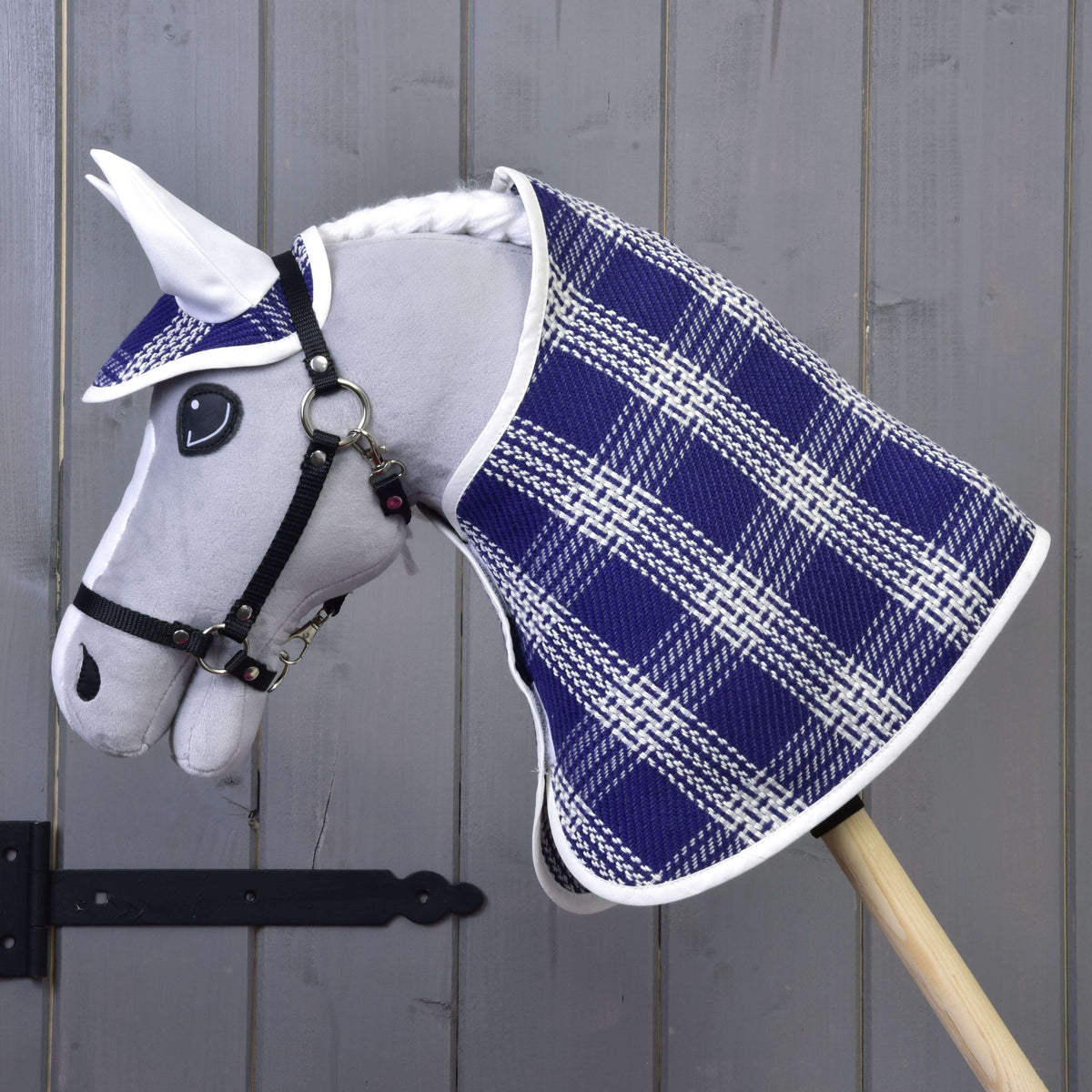 Side view of a grey Hobby Horse in the blue and white checked blanket and ear bonnet with white ears