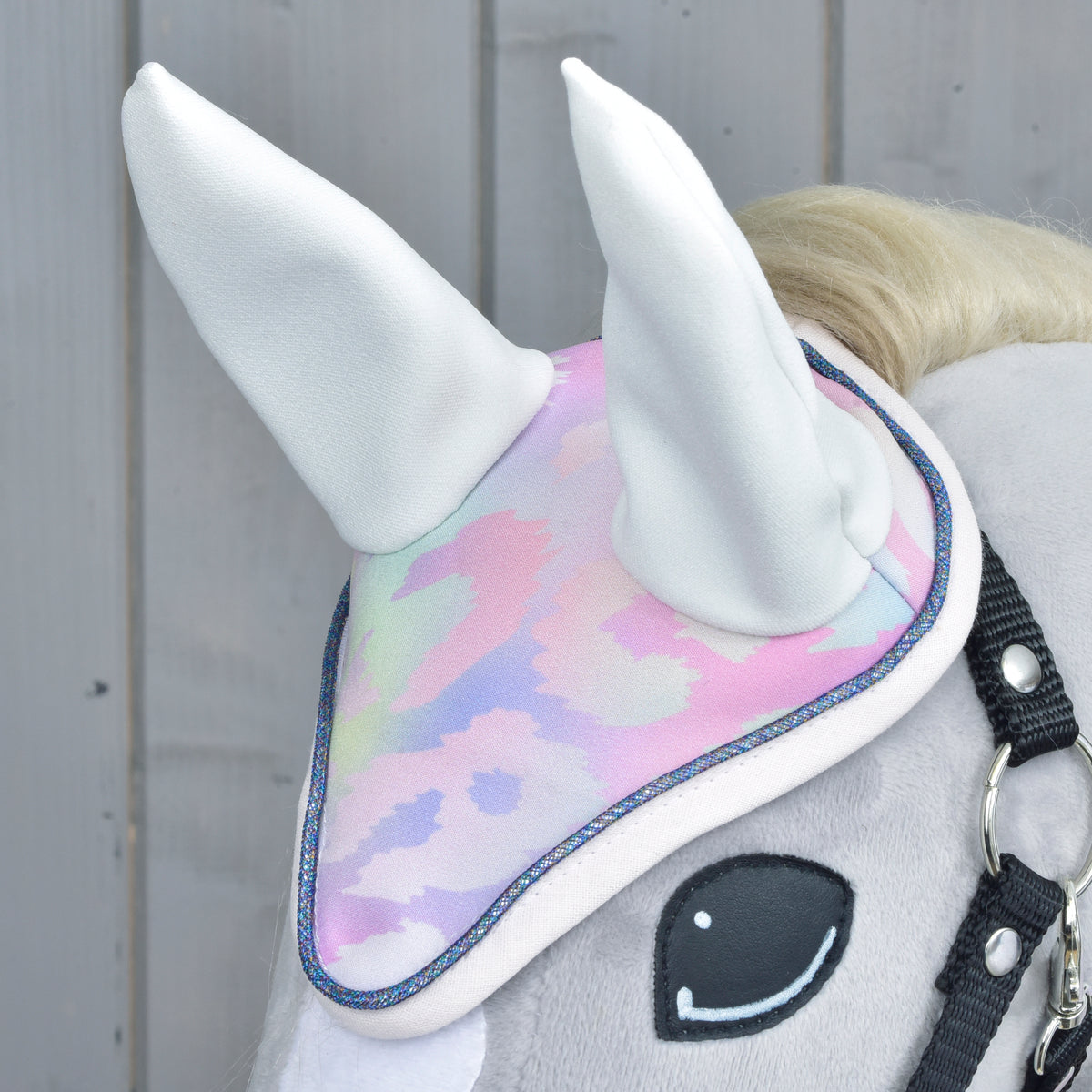 Close-up of the Hobby Horse ear bonnet with white ears, pastel leopard print and glittery blue piping on a grey horse