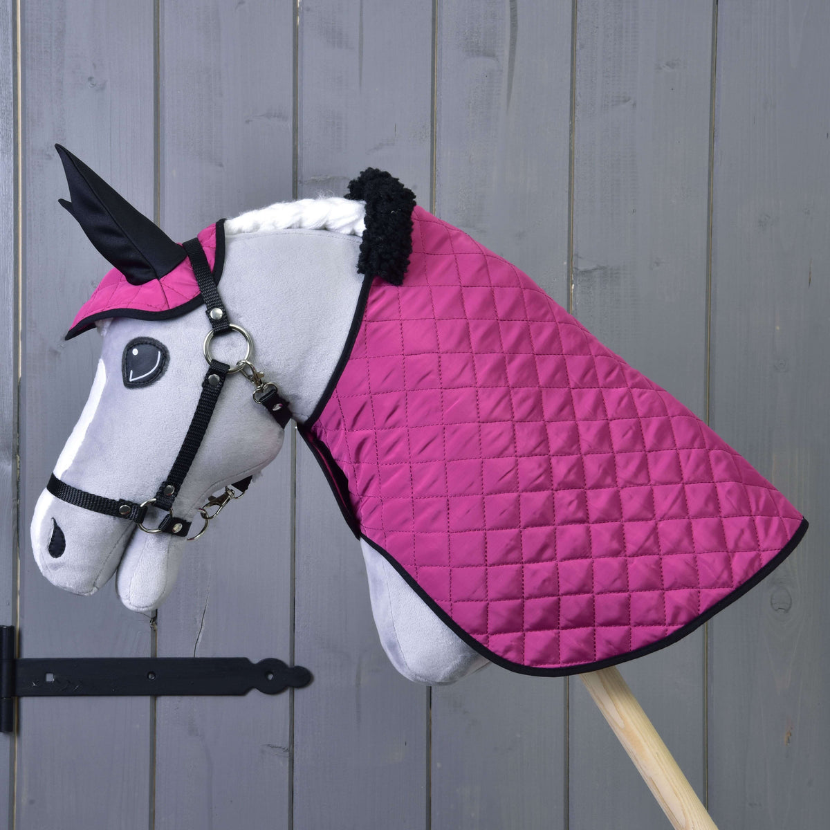 Szürke Hobby Horse ló fekete kötőfékben, rajta a Thermo Pink szett: steppelt takaró fekete szőrmegallérral és fülvédő
