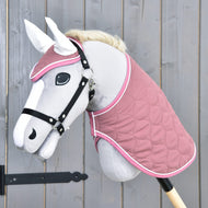 Light grey Hobby Horse with a black halter wearing the quilted dusty pink blanket and ear bonnet with white ears