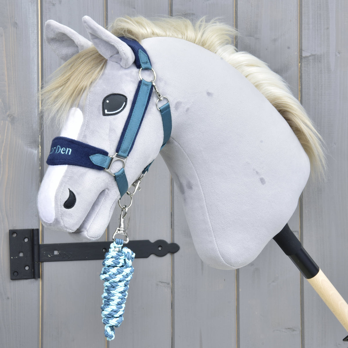 Exclusive Blue kötőfék egy krémszínű sörényű szürke Hobby Horse lovon, az álla alatt feltekert világos- és sötétkék vezetőszárral