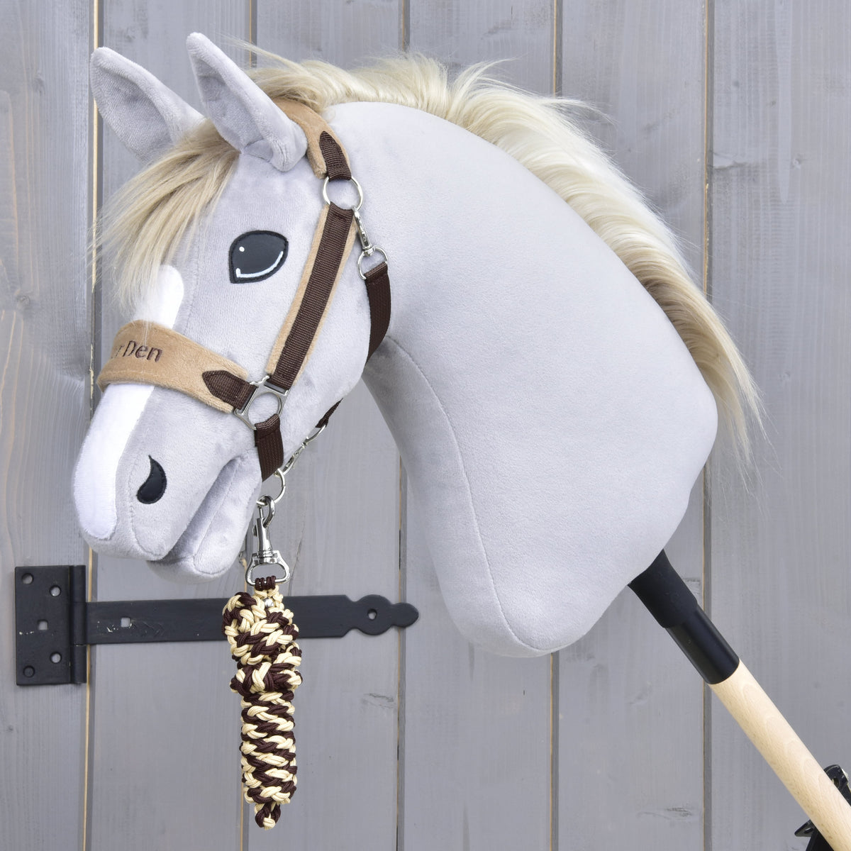 Exclusive Braun halter on a grey Hobby Horse with a white blaze, the brown and cream braided lead rope coiled below the chin