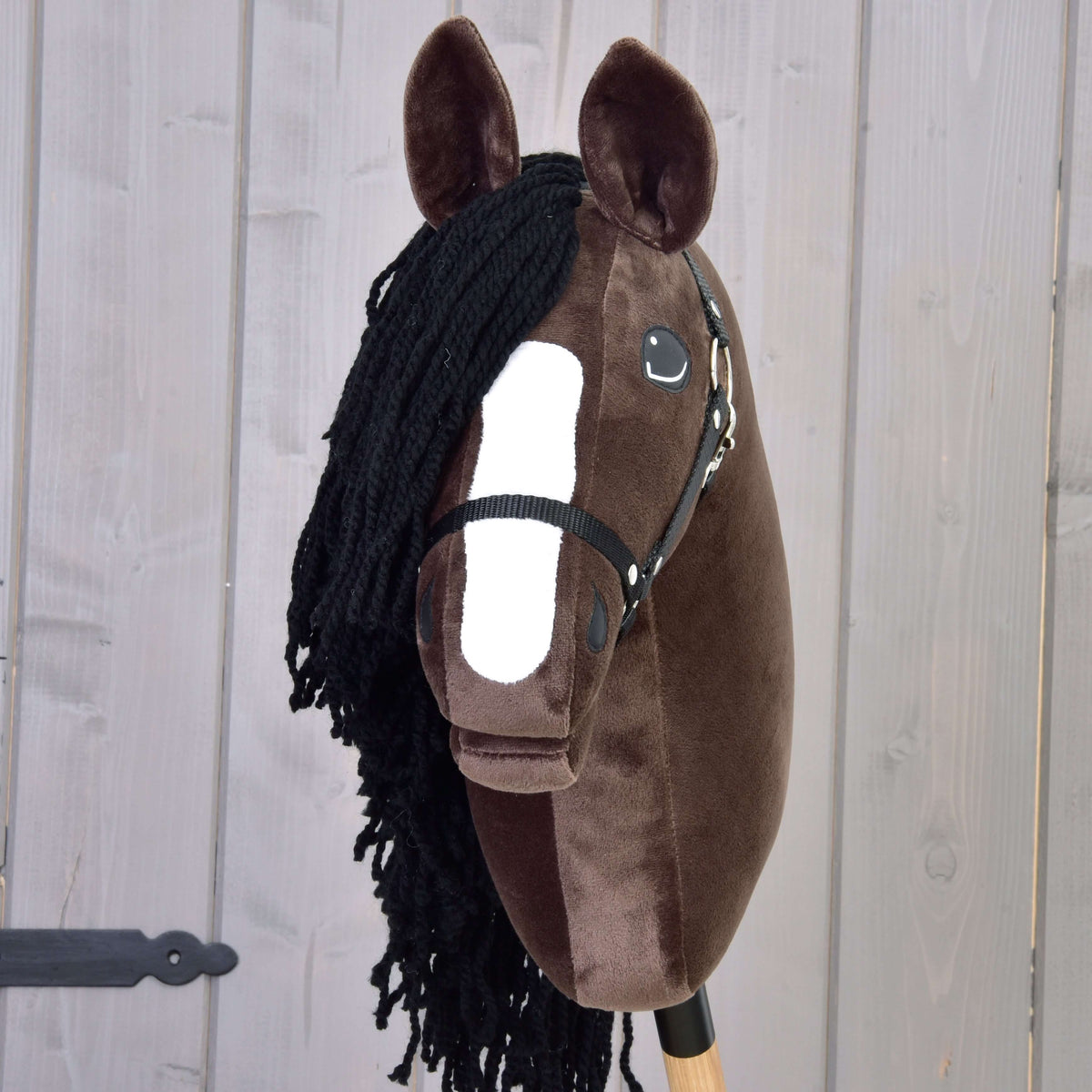 A sötétbarna Hobby Horse Sisi ló elölnézetből, fehér hókával, fekete fonalüstökkel és fekete kötőfékkel