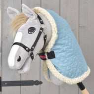 Grey Hobby Horse in a black halter wearing the light blue quilted Stable Blanket Sky Blue with cream fleece edging