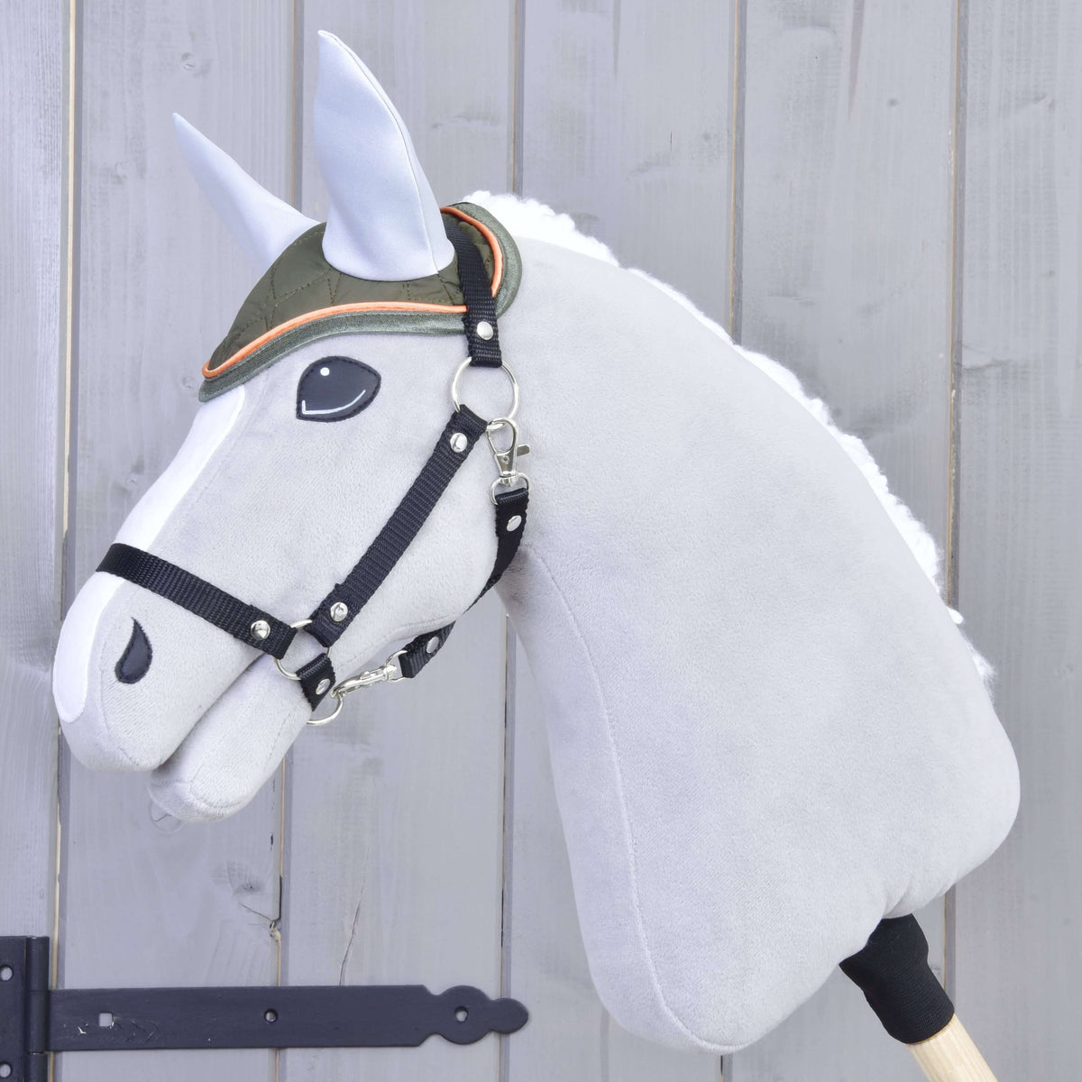 Fekete kötőfékes szürke Hobby Horse ló az olívazöld steppelt fülvédőben, világosszürke fülekkel