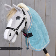 Light grey Hobby Horse with a black halter wearing the teal corduroy stable blanket with a cream teddy collar
