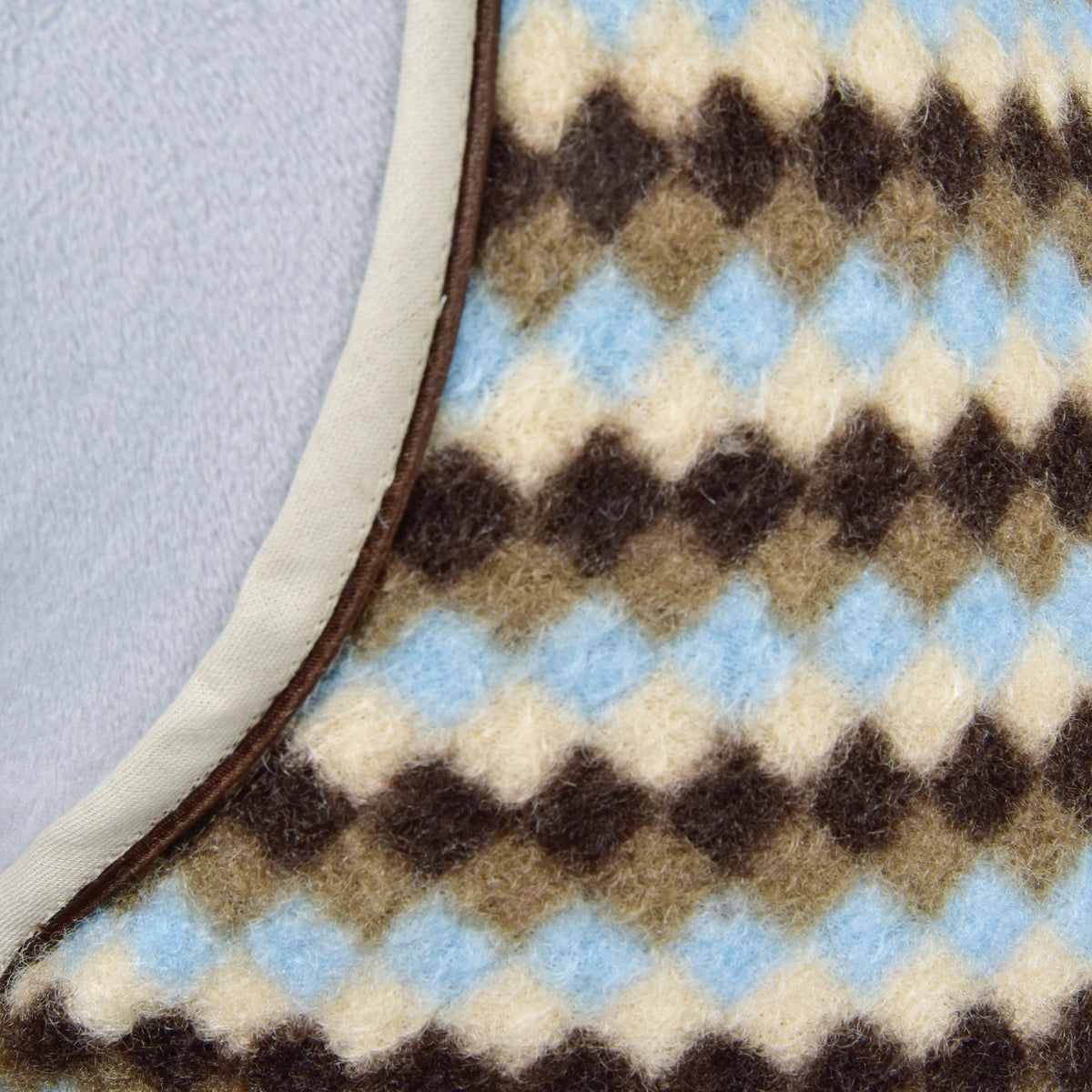 Makrofotó a Pastel Argyle Hobby Horse istállótakaró barna, szürkésbarna, krémszínű és világoskék rombuszmintás polárjáról és bézs szegélyéről