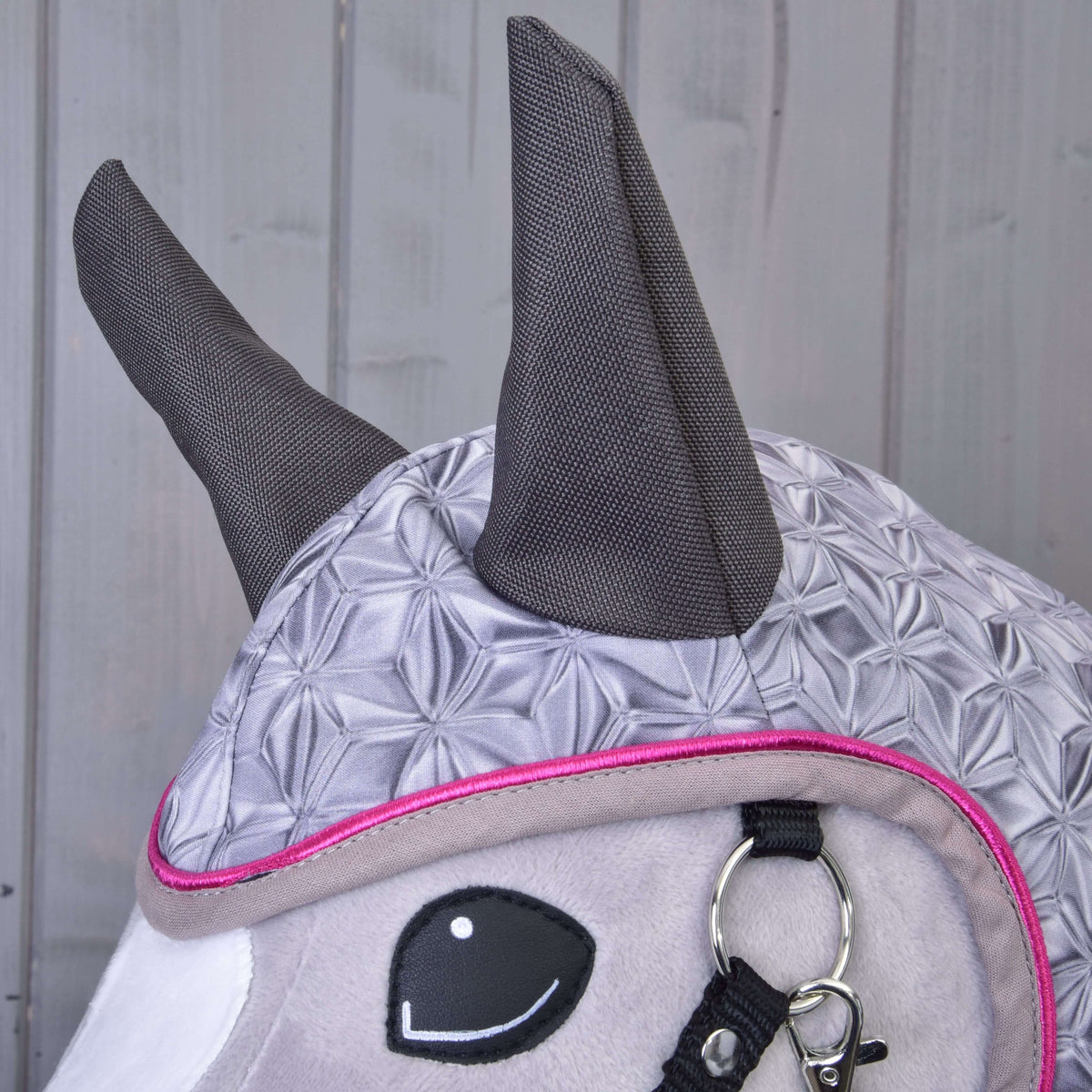 Close-up of the dark grey ears and shimmering geometric print on the hood of the Raincoat Valentine
