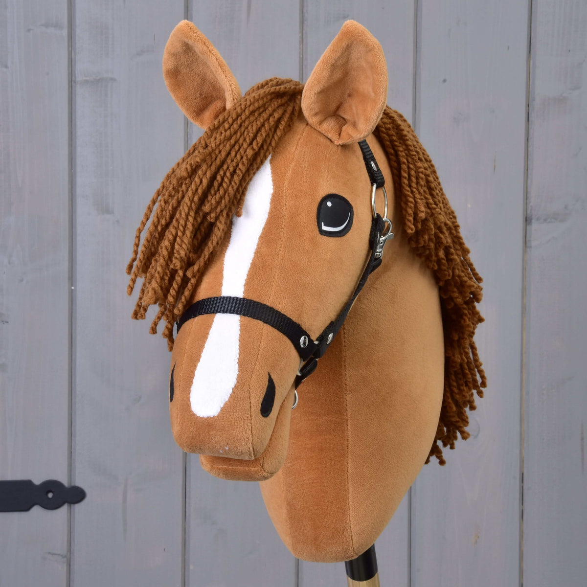 Front view of Hobby Horse Wendy with the white stripe down her face, black halter and brown yarn forelock