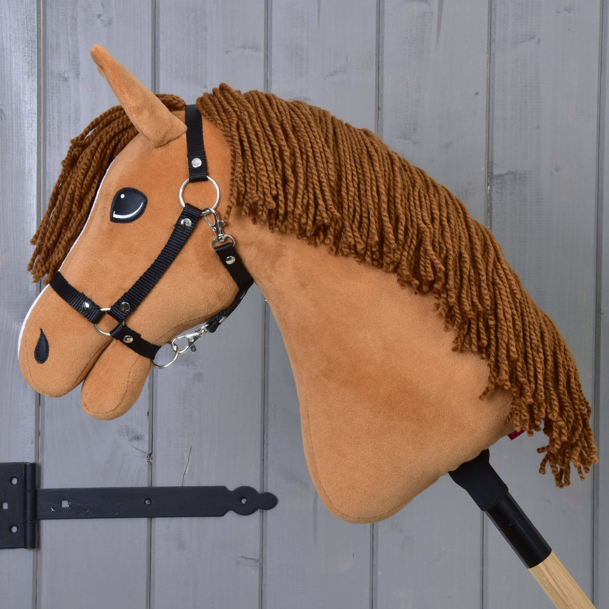 Side profile of Hobby Horse Wendy showing her long brown yarn mane, black halter and chestnut plush