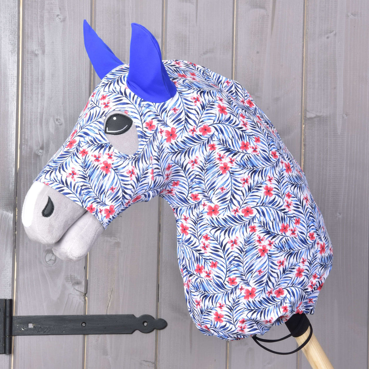 LarDen Hobby Horse Avatar védőruha (Lycra) egy szürke fejen: fehér, kék pálmalevelekkel, piros virágokkal és kék fülekkel