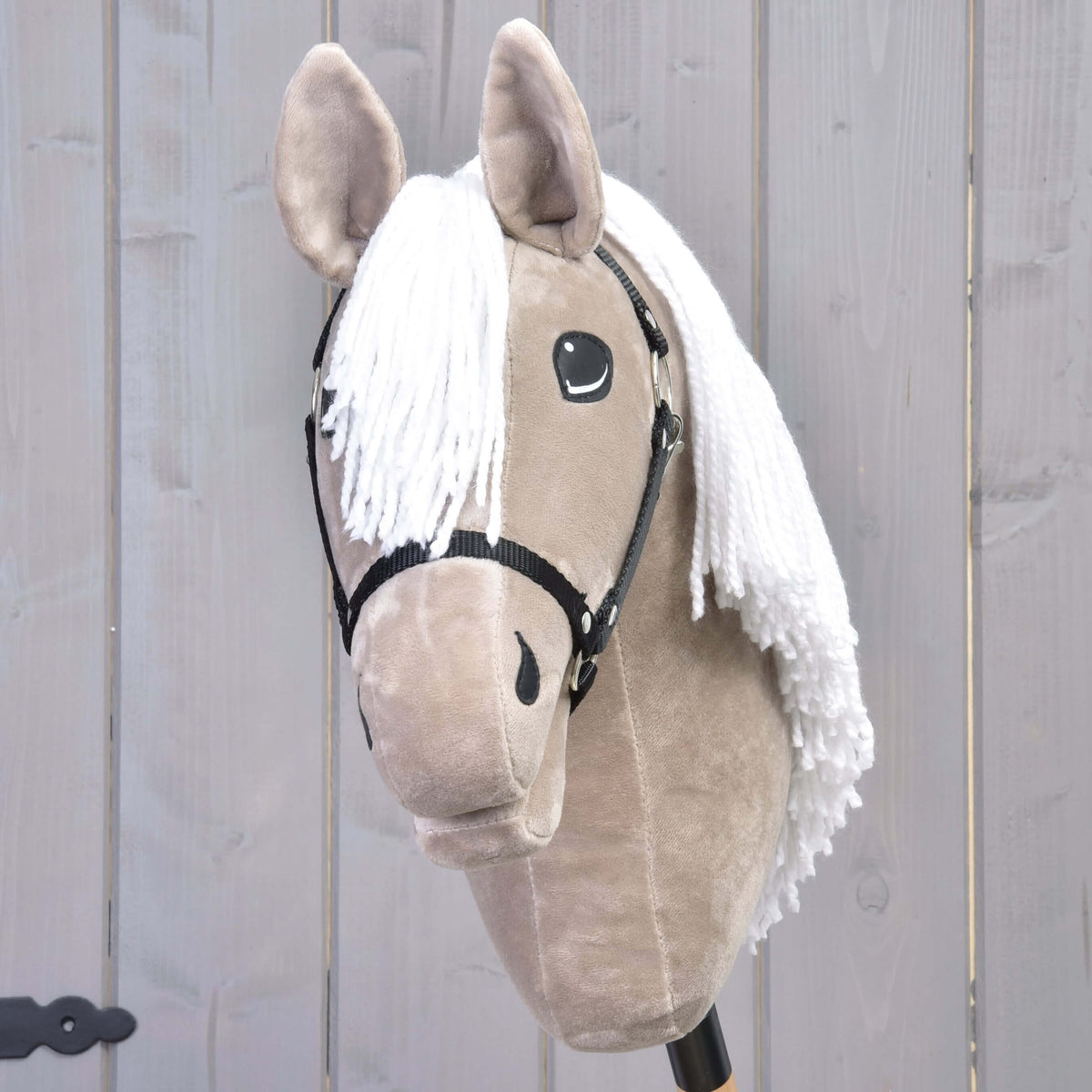 Hobby Horse Blondie fekete kötőfékkel elölről, a bézs plüssfülek között fehér fonalüstök hullik alá