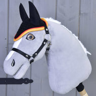 Szürke plüss Hobby Horse ló a fekete horgolt Flag fülvédőben, piros-sárga szegéllyel és fekete kötőfékkel
