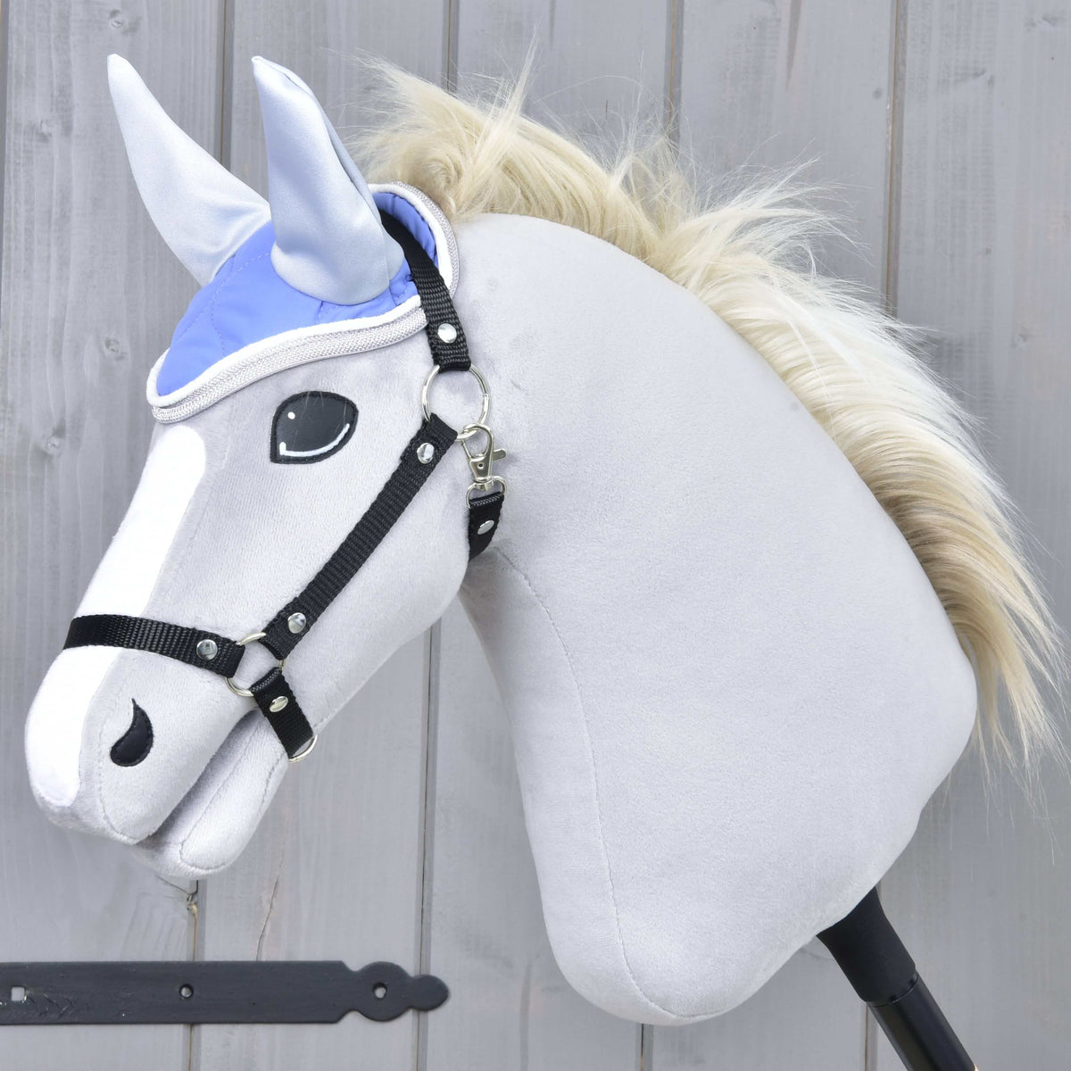Szőke sörényű, szürke Hobby Horse ló fekete kötőfékben, a világosszürke fülű Light Violett fülvédővel