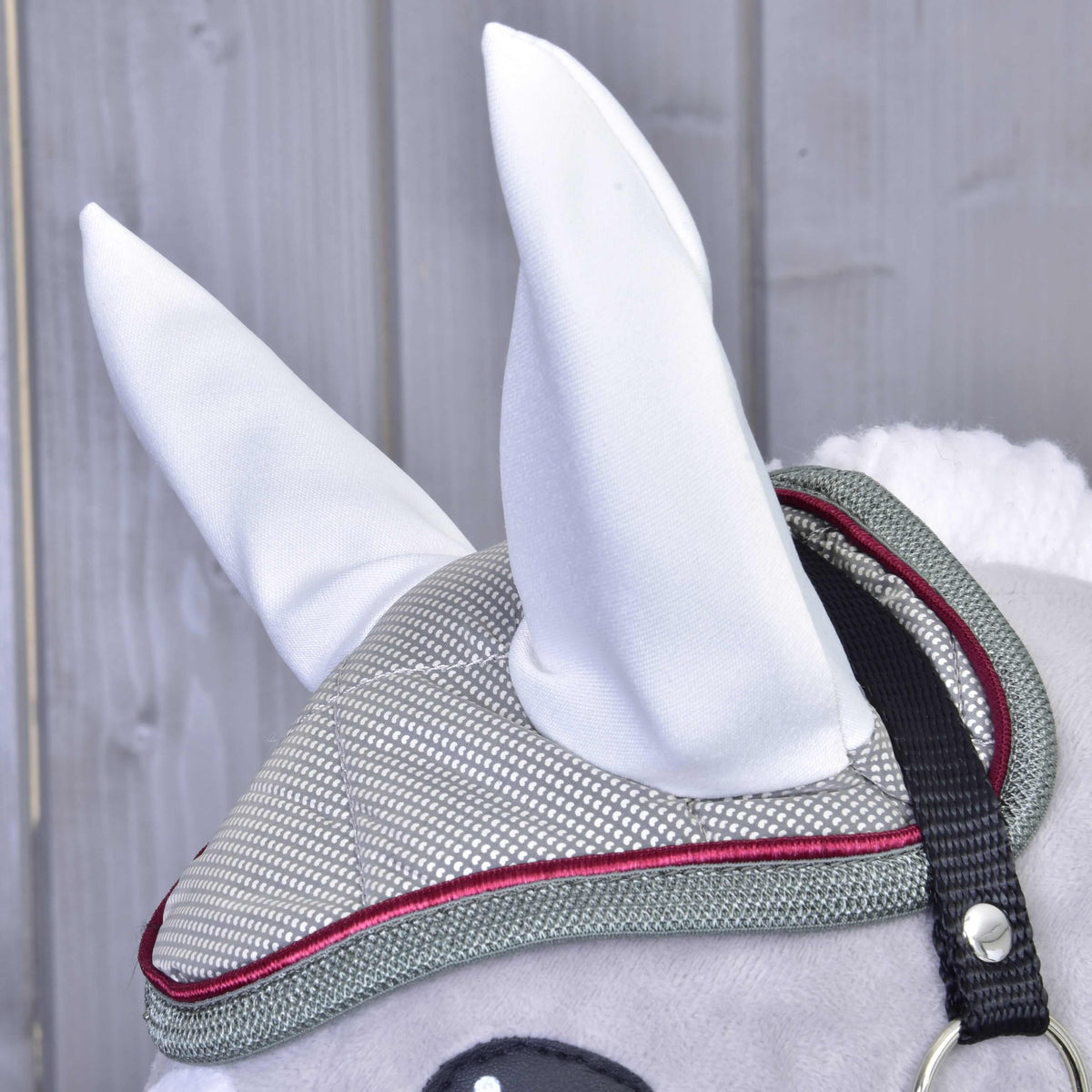 Side close-up of the quilted silver ear bonnet with raspberry piping, grey binding and tall white ears