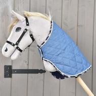 Szürke Hobby Horse ló fekete kötőfékben, a nyakán a steppelt, skótkockás szegélyű Beautiful Jeans takaróval