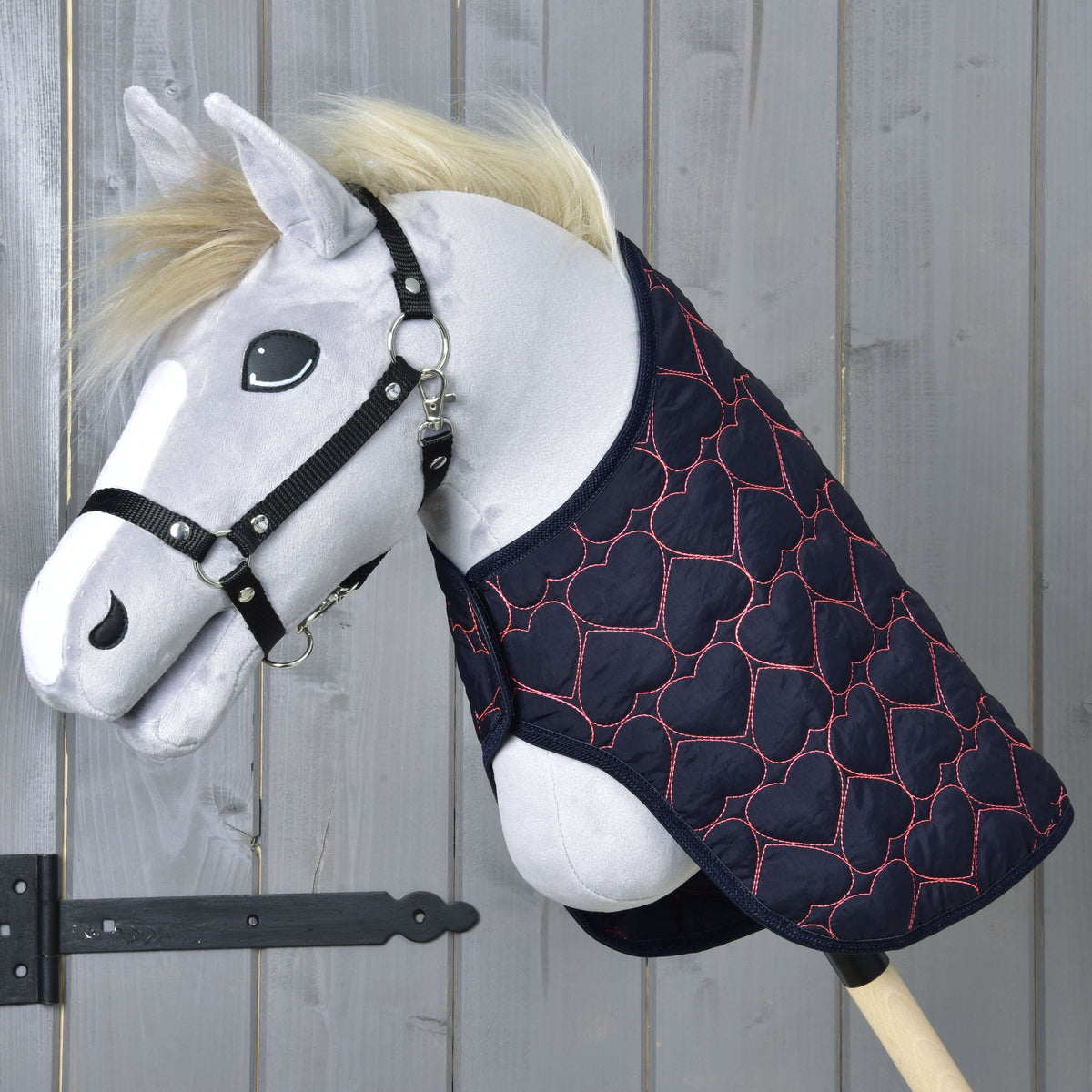 Grey Hobby Horse with a blond mane and black halter wearing the navy Blanket Pink Heart over its neck