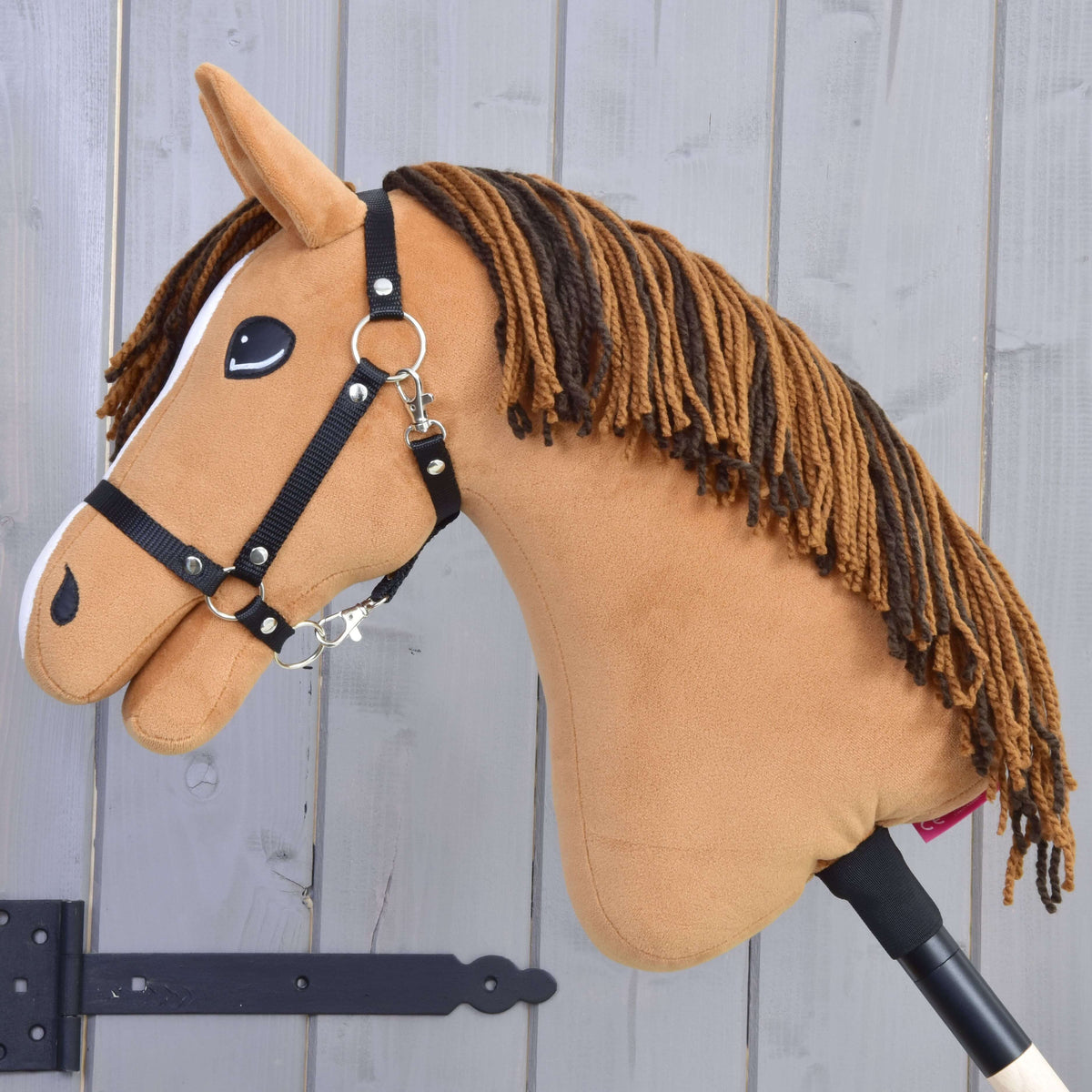 Hobby Horse Edward in left profile with a long mane of light and dark brown yarn and a black halter
