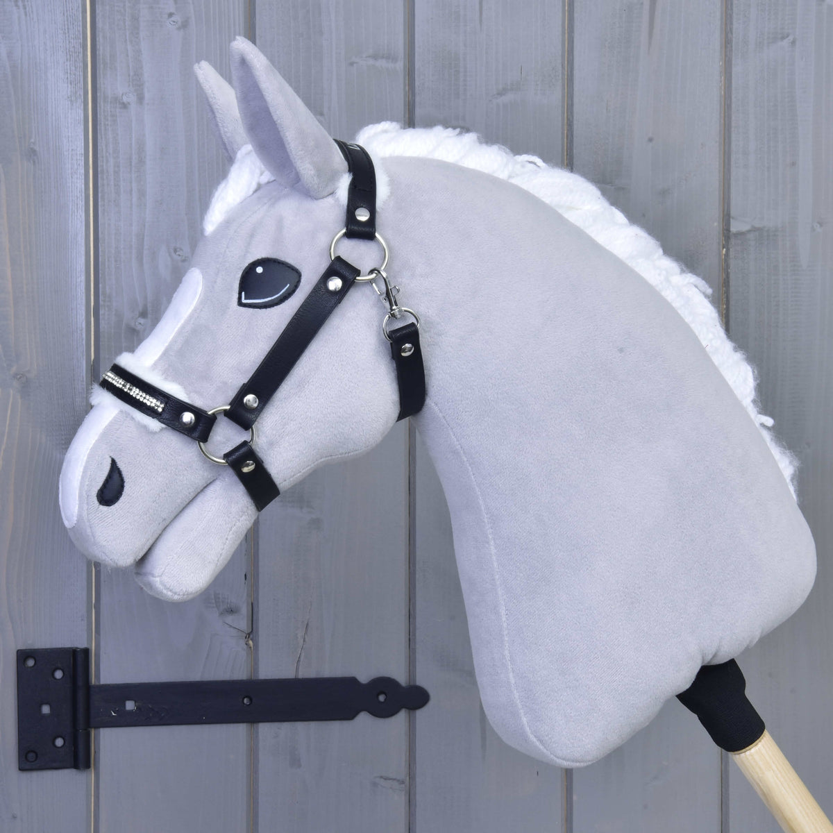 Fehér sörényű világosszürke Hobby Horse ló a fekete műbőr kötőfékben, fehér szőrmével és strasszkövekkel
