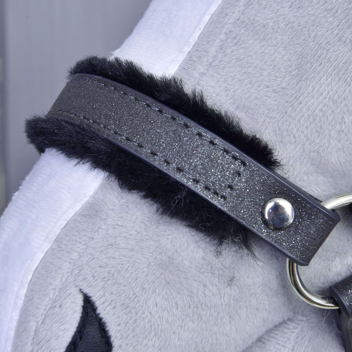 Detail of the sparkly graphite leatherette noseband with black fur trim, neat stitching and a silver rivet