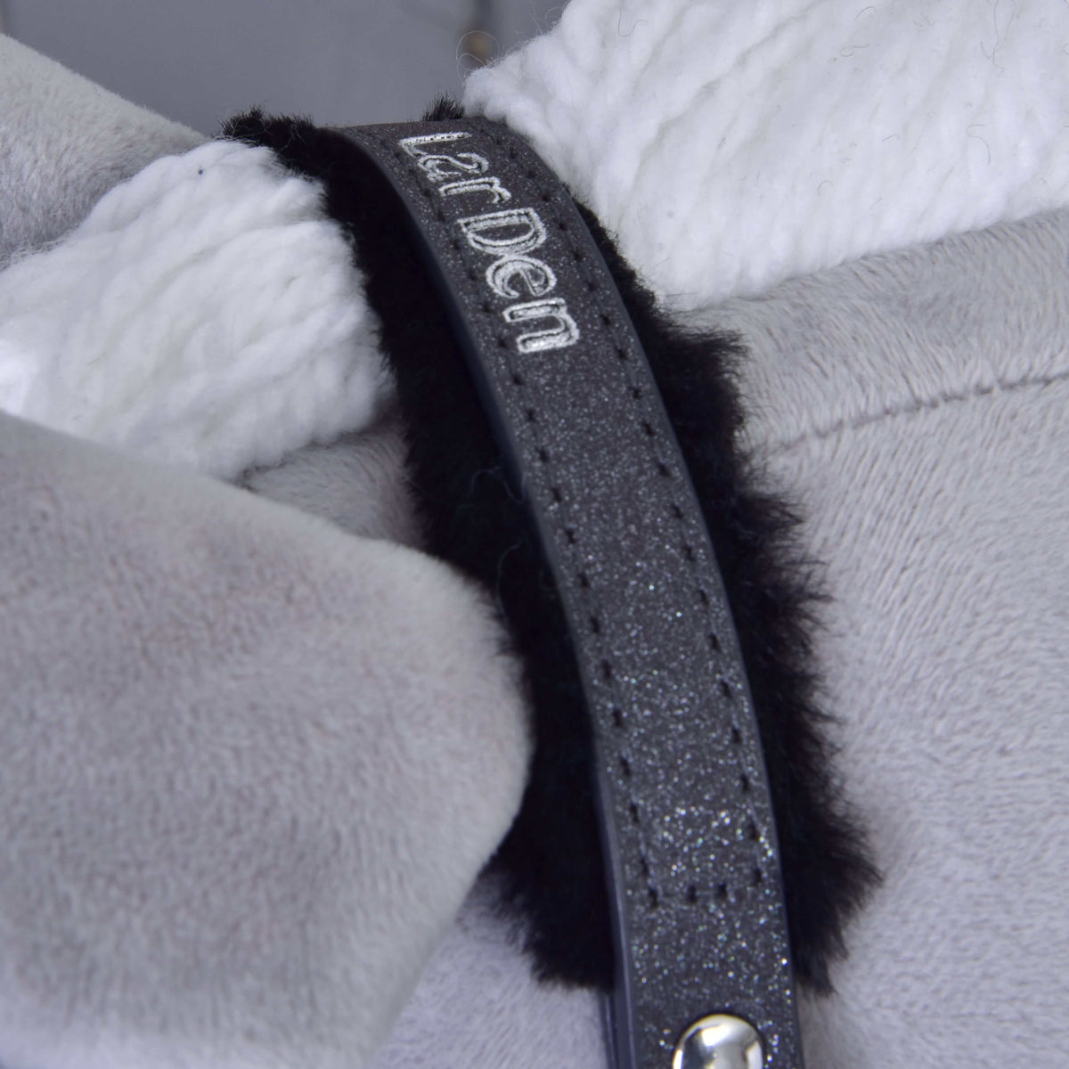 Close-up of the graphite crownpiece with silver embroidered LarDen lettering and black fur by the white mane
